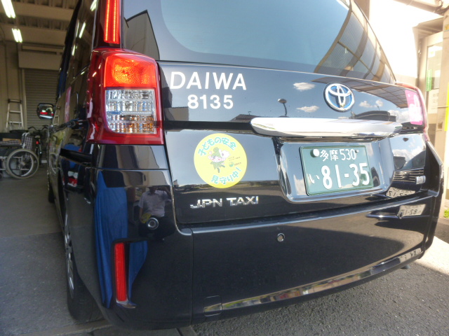 大和交通保谷㈱のタクシー車両の後方に「子どもの安全見守り中！」のステッカーが貼られている写真。