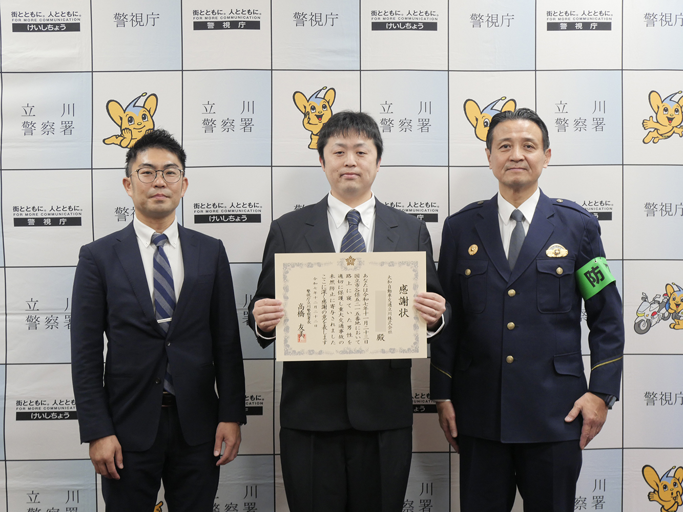 大和自動車交通立川㈱の澤田社長、タクシー乗務員、立川警察署の方、3名による集合写真。